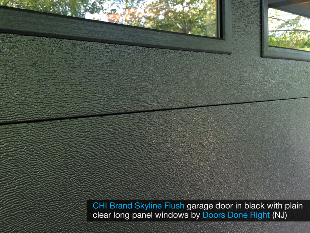 chi model 2284 skyline flush garage door in black with clear long panel windows in top door section - wood grain closeup